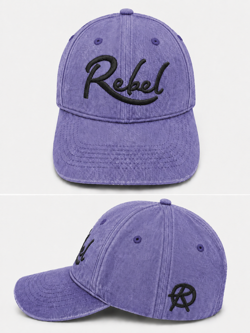 A purple washed cotton baseball cap shown from the front and side angles against a light gray background. The front features the word 'Rebel' embroidered in black script, and the side displays a small Anarchy inspired embroidered 'R' logo.