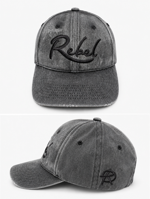 A black washed cotton baseball cap shown from the front and side angles against a light gray background. The front features the word 'Rebel' embroidered in black script, and the side displays a small Anarchy inspired embroidered 'R' logo.